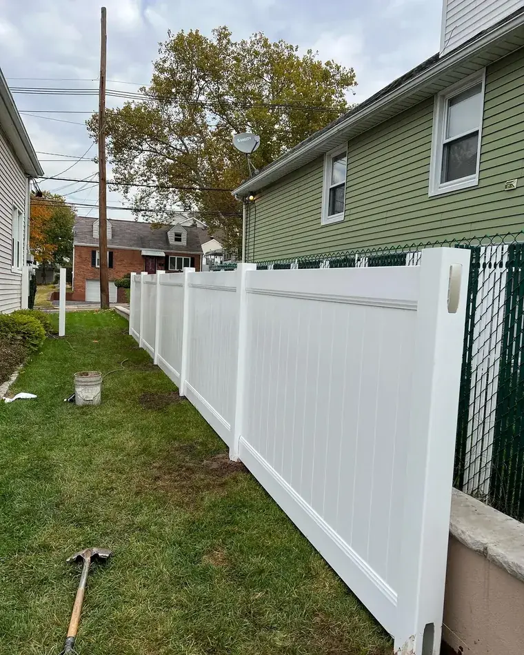 Vinyl Privacy Fence Beside a Painted House